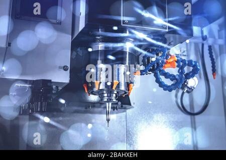High precision CNC milling machine, operator machining metal part process in factory Stock Photo