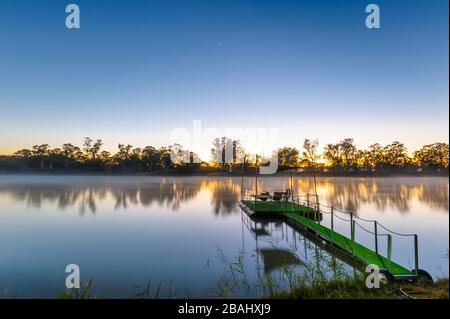 Synthetic grass carpet on pontoon on the Murray River as the sun rises in Blanchetown, South Australia. Stock Photo