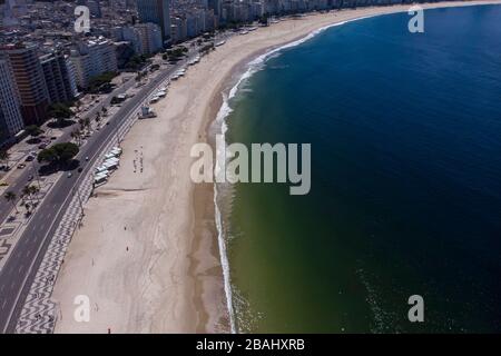 Near empty Copacabana beach and boulevard in Rio de Janeiro during the COVID-19 Corona virus outbreak at a sunny summer midday [March 27, 2020]