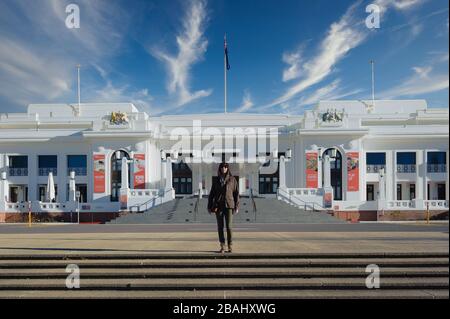 Female tourist standing on top of the stairs leading to the entrance of Old Parliament House in Canberra, Australian Capital Territory. Stock Photo