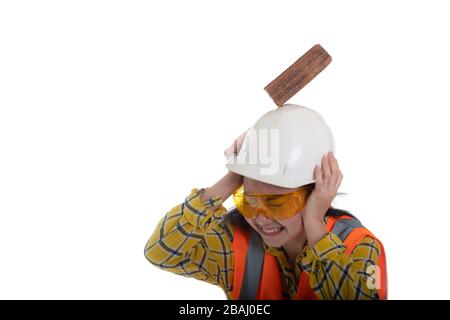 The stick block brick fell on the Asia engineer young woman head on the helmet worker at white background, Area construction safety first concept Stock Photo