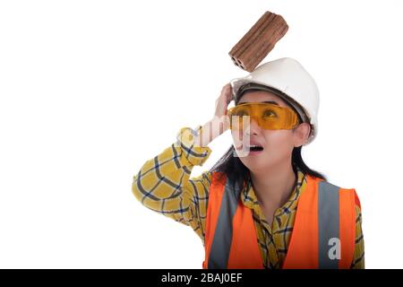 The stick block brick fell on the Asia engineer young woman head on the helmet worker at white background, Area construction safety first concept Stock Photo