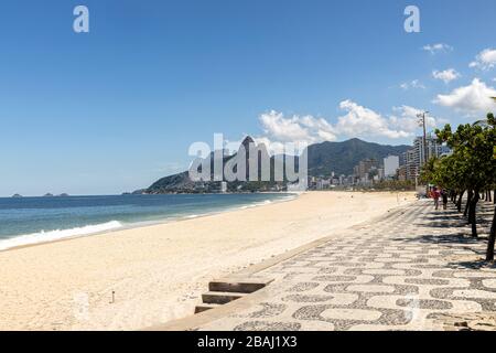 Deserted Ipanema and Leblon beach with the Two Brothers mountain in the background during the COVID-19 Corona virus outbreak on a sunny midday in Rio Stock Photo