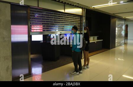 Hong Kong, CHINA. 28th Mar, 2020. Young couple awaiting outside the cinema theatre in the shopping arcade. All local cinemas ( theatres ) will be closed temporarily from 6 pm today until 10th of April 2020 HK TIME for 14 days to combat spreading coronavirus infections in the City introduced by China Pneumonia.Mar-28, 2020 Hong Kong.ZUMA/Liau Chung-ren Credit: Liau Chung-ren/ZUMA Wire/Alamy Live News Stock Photo