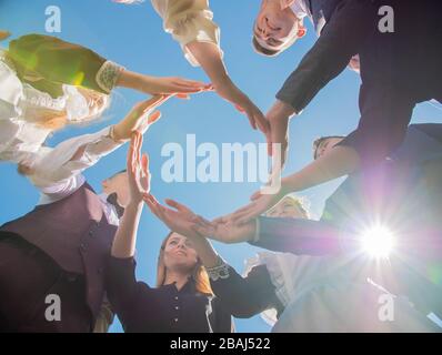 A group of friends make a circle shape out of their hands. The concept of world peace. Stock Photo