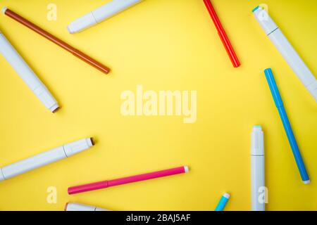 Colored markers and felt-tip pens on a yellow background. Back to school. Stock Photo