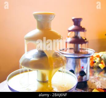 melted black and white chocolate fountain that descends sweet and soft for your fruit or pastries Stock Photo