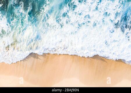 View from above, stunning aerial view of waves crashing onto a beautiful beach during a sunny day. Nyang Nyang Beach, South Bali, Indonersia Stock Photo