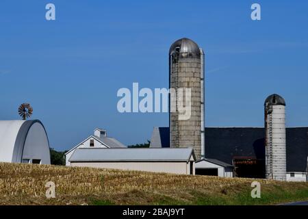 Overview of freshly harvested corn fields with stumps sticking out and the farmstead with silos in the background Lancaster County Pennsylvania Stock Photo