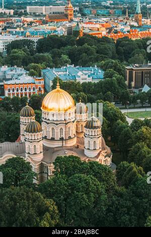 Riga, Latvia. Riga Cityscape. Top View Of Riga Nativity Of Christ Cathedral - Famous Church And Landmark In Summer Evening. Golden Yellow Domes. Stock Photo