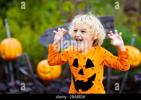 Child in Halloween costume. Kids trick or treat. Little boy dressed with pumpkin lantern. Family celebration. Stock Photo