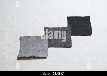 square pieces of multi-colored fabric laid out on a gray background Stock Photo