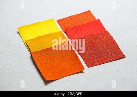 square pieces of multi-colored fabric laid out on a gray background Stock Photo