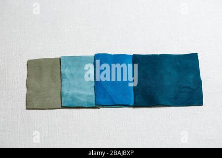 square pieces of multi-colored fabric laid out on a gray background Stock Photo