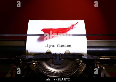 Vintage typewriter with bird feather. Light fiction genre concept Stock Photo