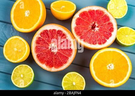 juicy oranges, grapefruits, limes and lemons lie on a blue wooden table. citrus fruits vitamins. view from above Stock Photo