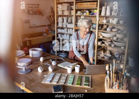 Portrait of senior female pottery artist in her art studio Stock Photo ...