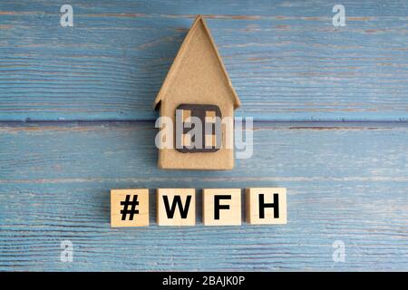 Concept image a wooden block and word - #WFH ( WORK FROM HOME ) on wooden background Stock Photo