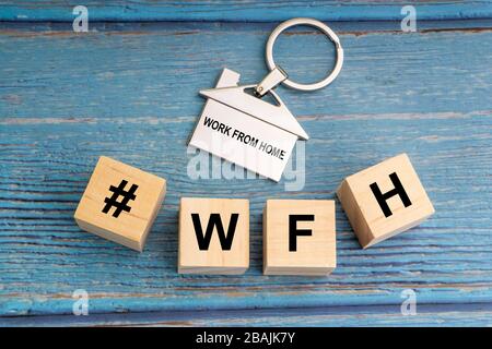Concept image a wooden block and word - #WFH ( WORK FROM HOME ) on wooden background Stock Photo
