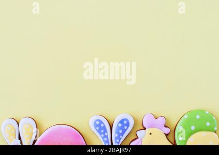 Easter background concept. Colored easter cookies on yellow background. Top view. Stock Photo