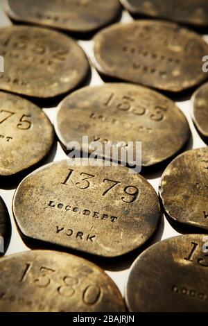 Vintage brass pay checks for staff from British Railways' York Locomotive Depot, UK. Stock Photo