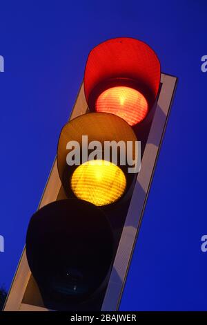 amber turning to red traffic light on road at twilight united kingdom Stock Photo
