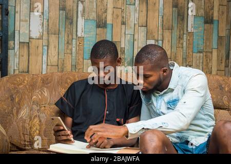 two african student studying their books and holding a smartphone Stock Photo