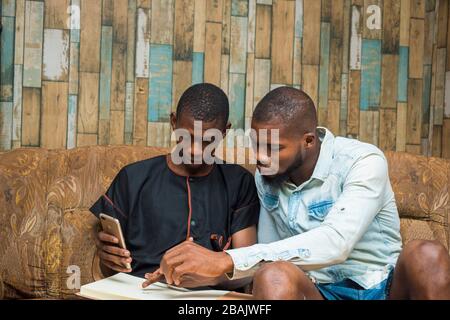 two african student studying their books and holding a smartphone Stock Photo