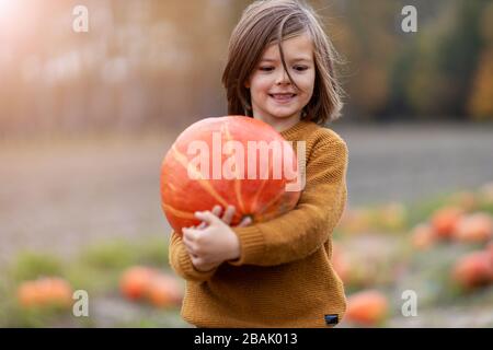 Cute little boy having fun in a pumpkin patch Stock Photo