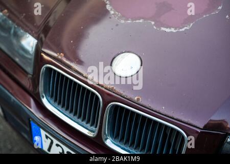 Strasbourg, France - Mar 18, 2020: Close-up macro detail of rusty BMW Series 3 logotype and front grille Stock Photo