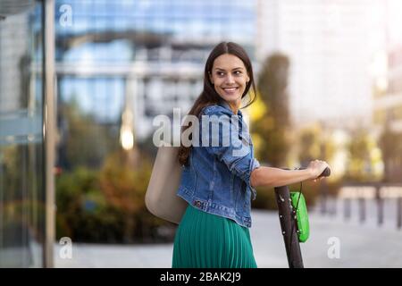 Female commuter riding electric push scooter Stock Photo