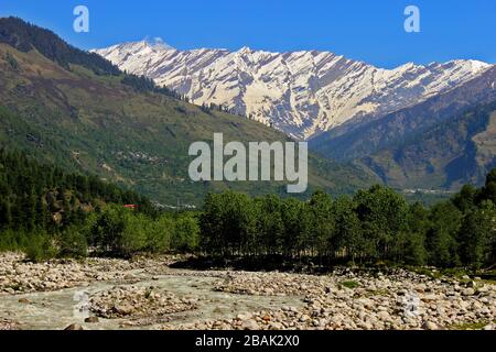 Snow clad himalayas viewed from The Beas River in Manali from Leh - manali highway in summer morning of May, India.Himachal Pradesh Stock Photo