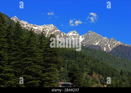 Snow clad himalayas viewed from The Beas River in Manali from Leh - manali highway in summer morning of May, India.Himachal Pradesh Stock Photo