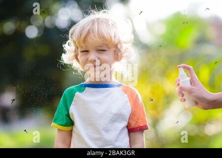 Mosquito on kids skin. Little boy attacked by mosquitoes in tropical forest. Insect repellent. Malaria and dengue fever prevention. Child scratching i Stock Photo