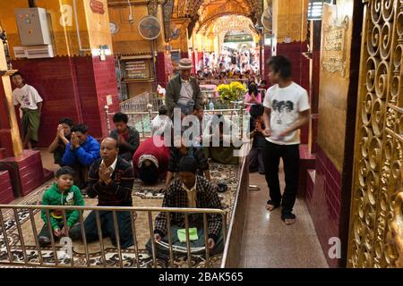 People praying in the Mahamuni Buddha Temple, Mandalay, Myanmar Stock Photo