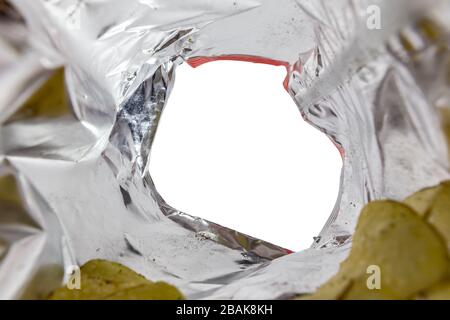 Creative view from inside a bag of potato chips with a hand reaching for a chip Stock Photo