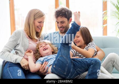 Happy young family with two children at home Stock Photo