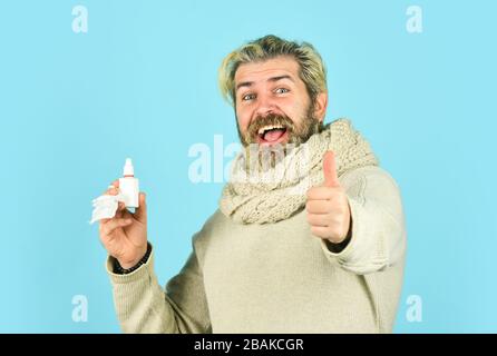 happy man says no to flu. coronavirus from china. immune system help during epidemic. healthcare in winter. best cold remedy. helpful nasal spray. man use nasal drops during course of disease. Stock Photo