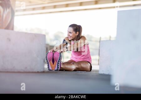Young woman doing fitness exercise in urban area Stock Photo