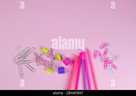 Multi-colored red and pinc pencils rulers, pens, pencils and scissors and stationery stand on a pink background Stock Photo