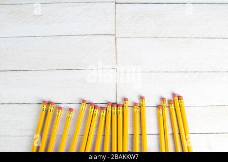 A set of orange pencils on a white wooden table. Printing supplies Stock Photo