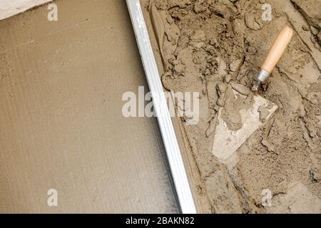 concrete screed floor align. trowel and rail on wet mortar Stock Photo