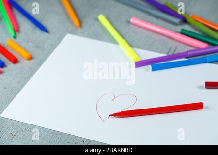 many multi-colored markers for drawing with drawings on white paper Stock Photo