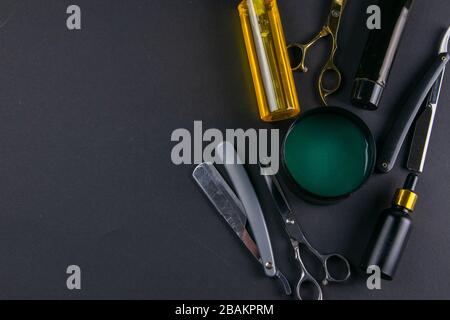 Scissors, hair clipper, combs, dangerous razor, gel for haircuts on black background. Hairdressing concept Stock Photo