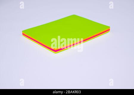 Top view of a stack of different colored paper sticky notes on top of a white desk Stock Photo