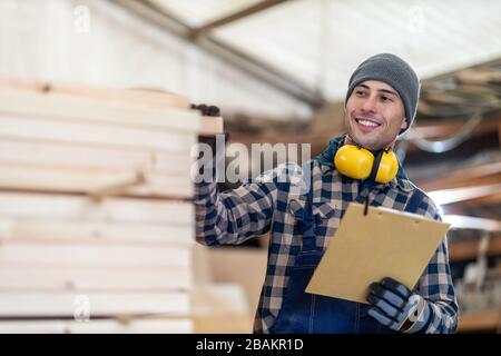 Young male worker in timber warehouse Stock Photo