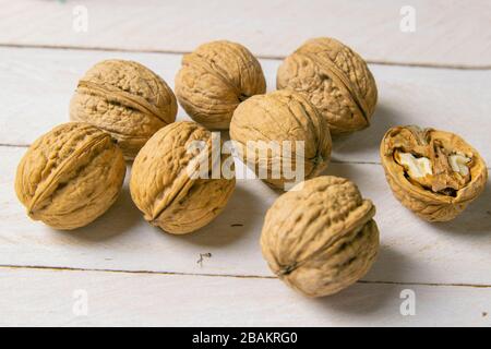 Closeup of walnuts scattered on a white wooden table Stock Photo