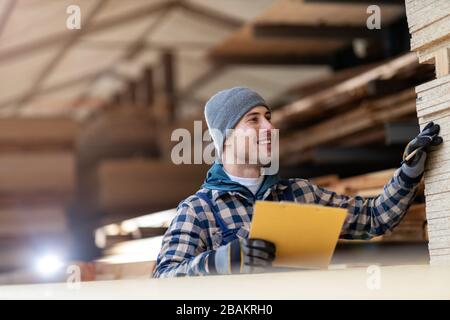 Young male worker in timber warehouse Stock Photo