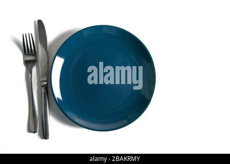 Blue empty plate with fork and knife isolated on white background Stock Photo