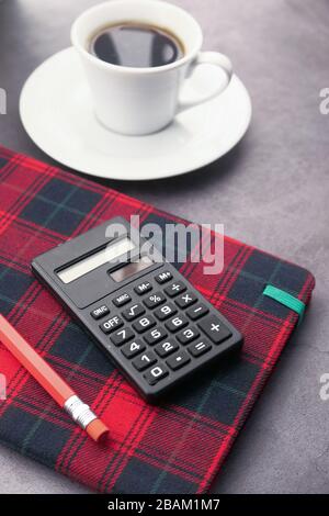 pencils, calculator notepad, and tea t on table at early morning  Stock Photo